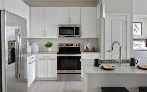 a kitchen with stainless steel appliances and white cabinets