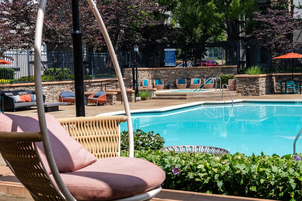 a swimming pool with a swinging chair next to it