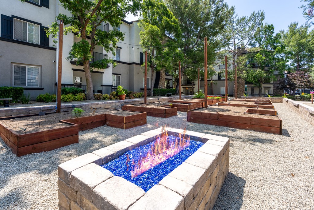 a fire pit in the middle of a courtyard with benches