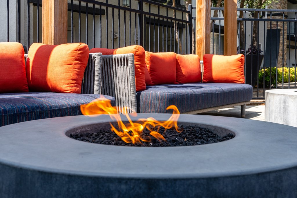 an outdoor seating area with chairs and a fire pit