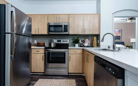 a kitchen with stainless steel appliances and wooden cabinets