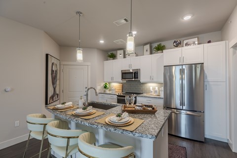 A modern kitchen with a dining table set for two.
