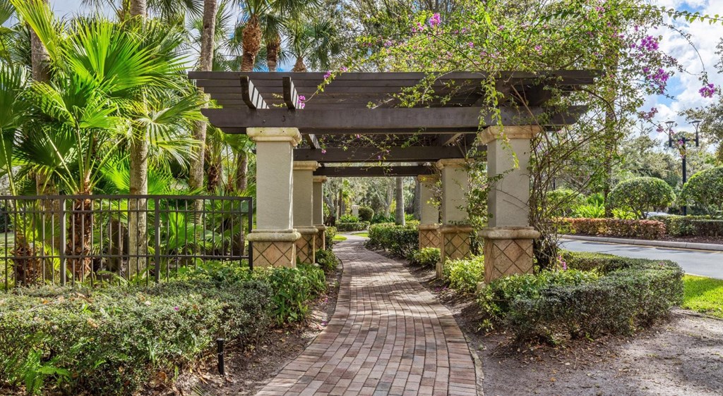 A pathway leads to a covered walkway with a bridge over it.