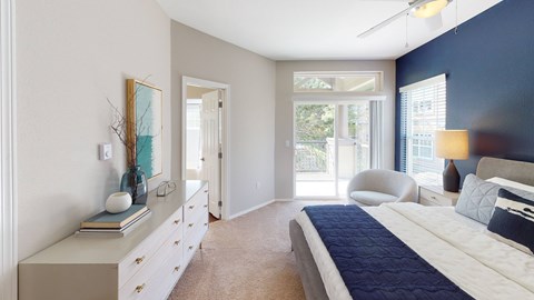 A bedroom with a large bed and a dresser with a mirror above it.