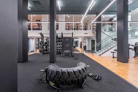 A gym with a variety of equipment including a tire flipping station.