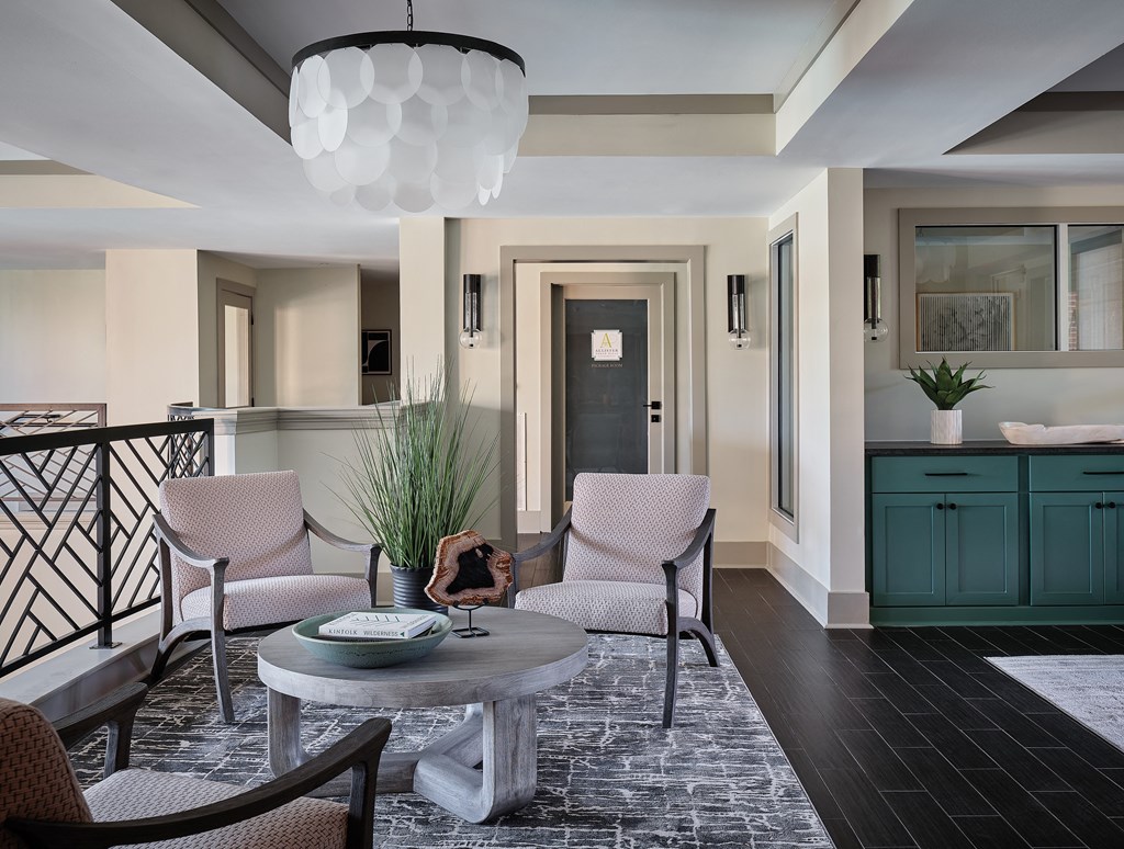 Elegant Lounge Area with Accent Lighting, Modern Chairs, and Green Cabinetry