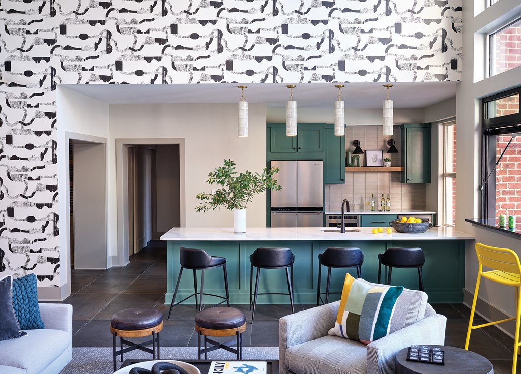 Modern Community Kitchen with Green Cabinetry, Bar Seating, and Lounge Area