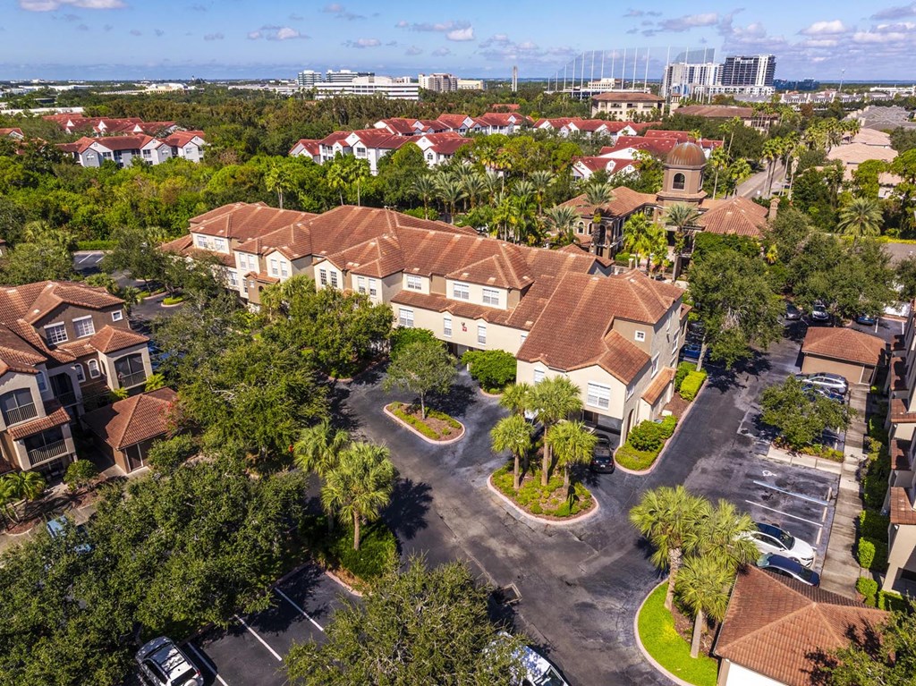 Aerial of apartment buildings with terracotta roofs and parking areas