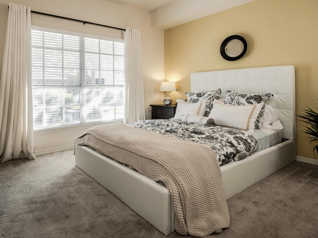 Bright bedroom with upholstered bed and large window