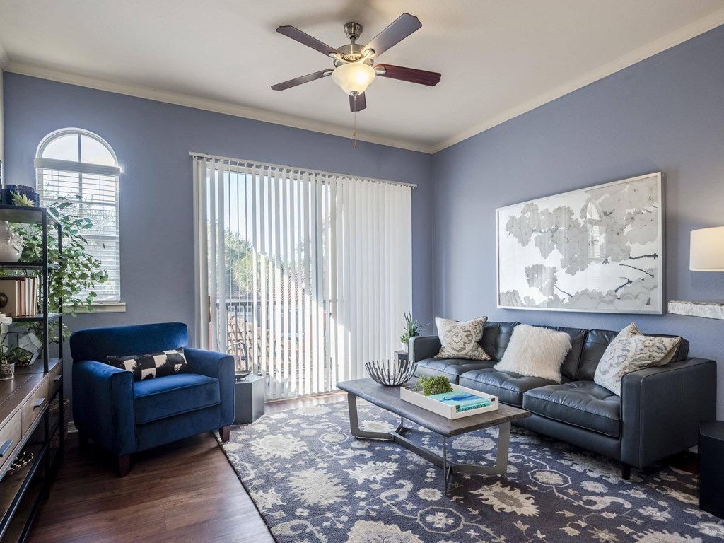 Living room with blue walls, leather sofa and balcony light