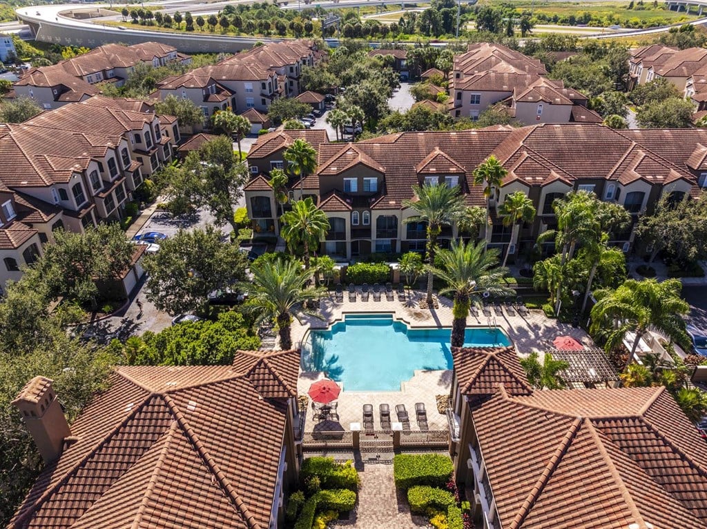 Aerial perspective of pool, clubhouse, and surrounding residential buildings