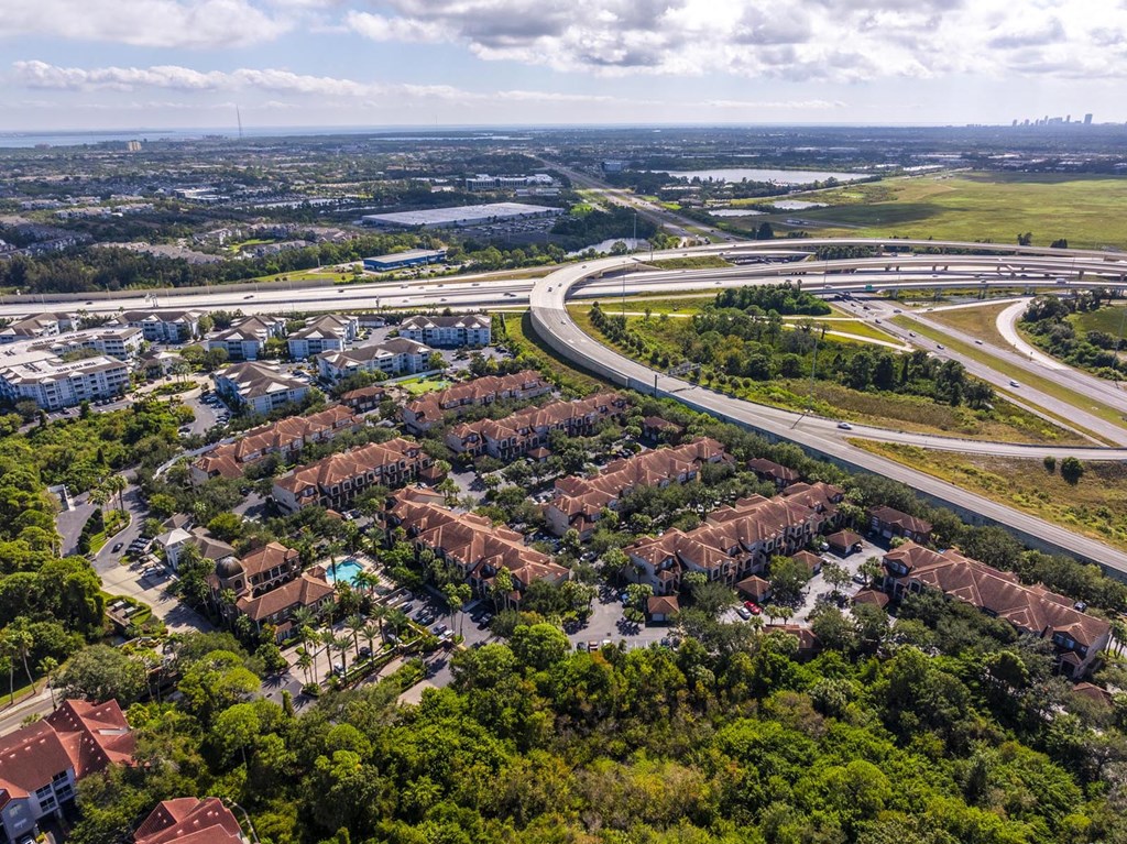 Overhead view of community surrounded by trees and connecting roadways