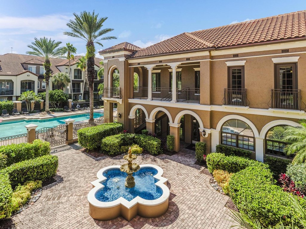 Resort-style courtyard with fountain and pool views surrounded by manicured landscaping.