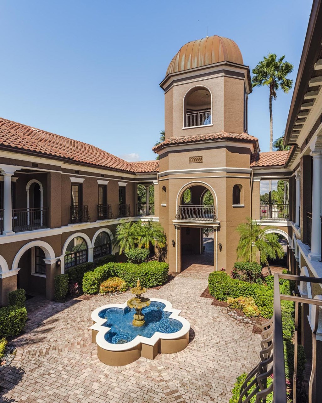 Central tower and fountain courtyard creating a grand entrance at Magnolia Carillon Apartments.