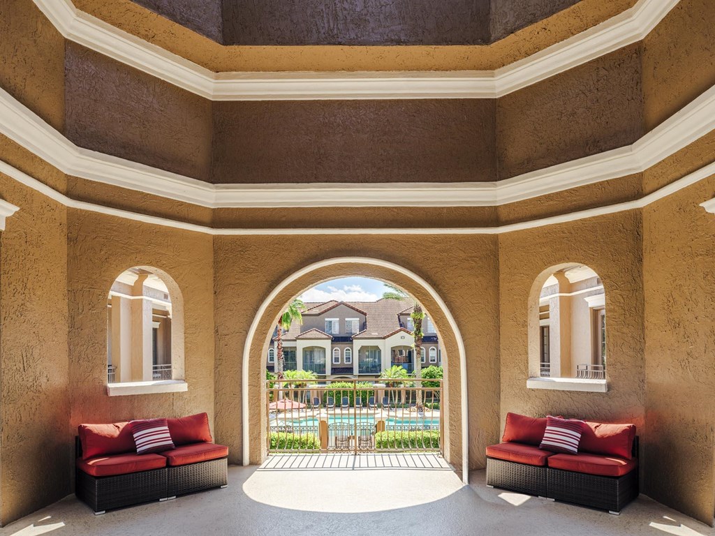 Covered seating area overlooking the pool and courtyard, perfect for relaxing outdoors.