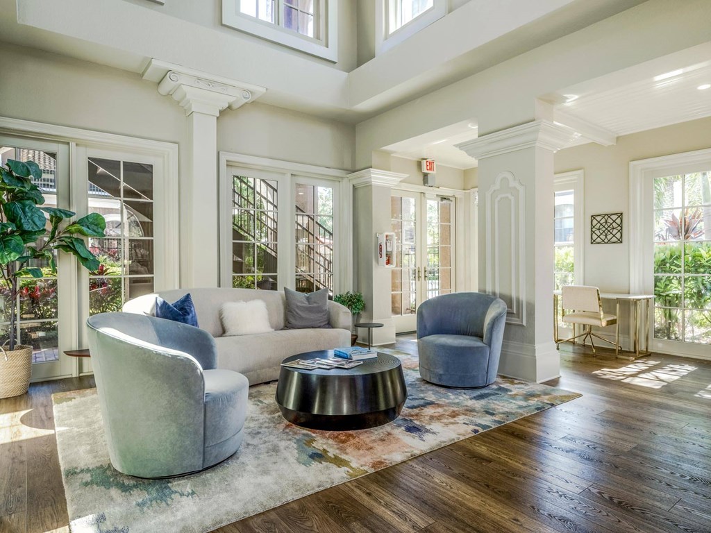 Elegant clubhouse seating area with large windows, plush chairs, and inviting design.