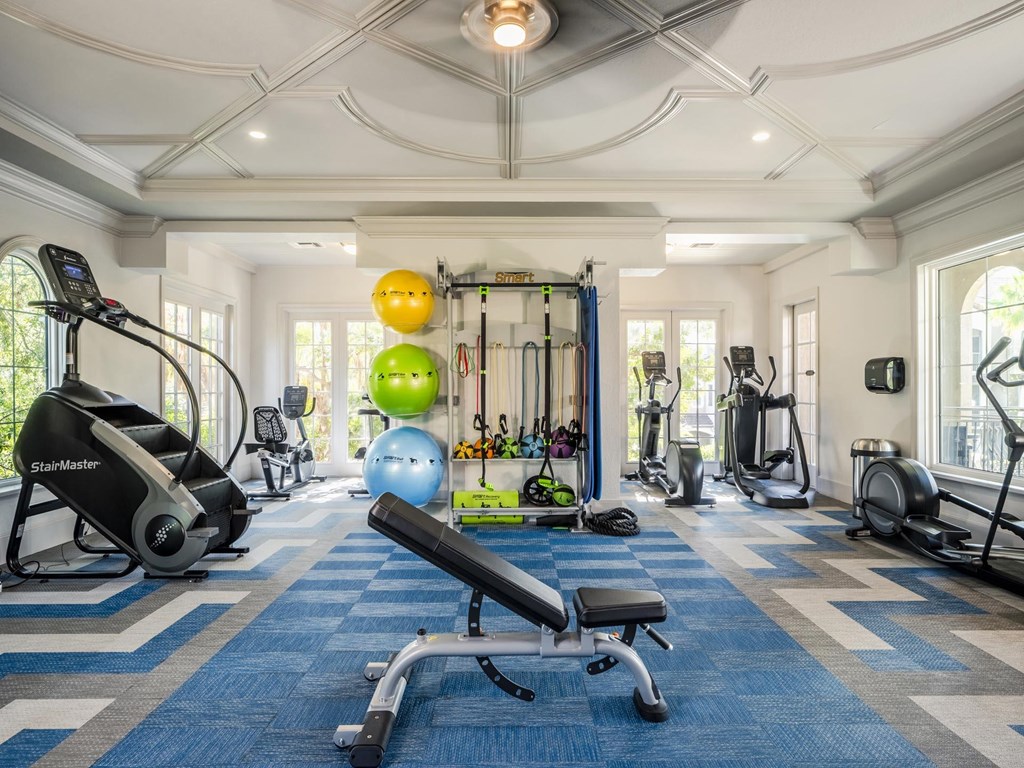 Spacious fitness center with stair climber, free weights, and functional training equipment.