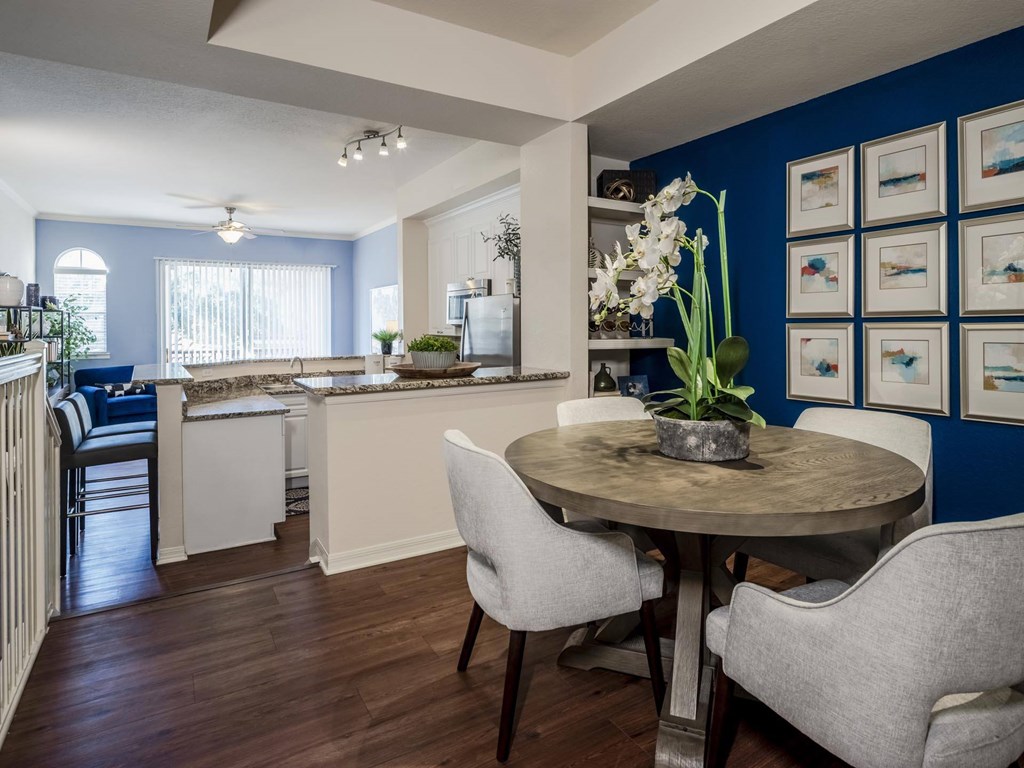 Dining nook with blue accent wall beside open kitchen