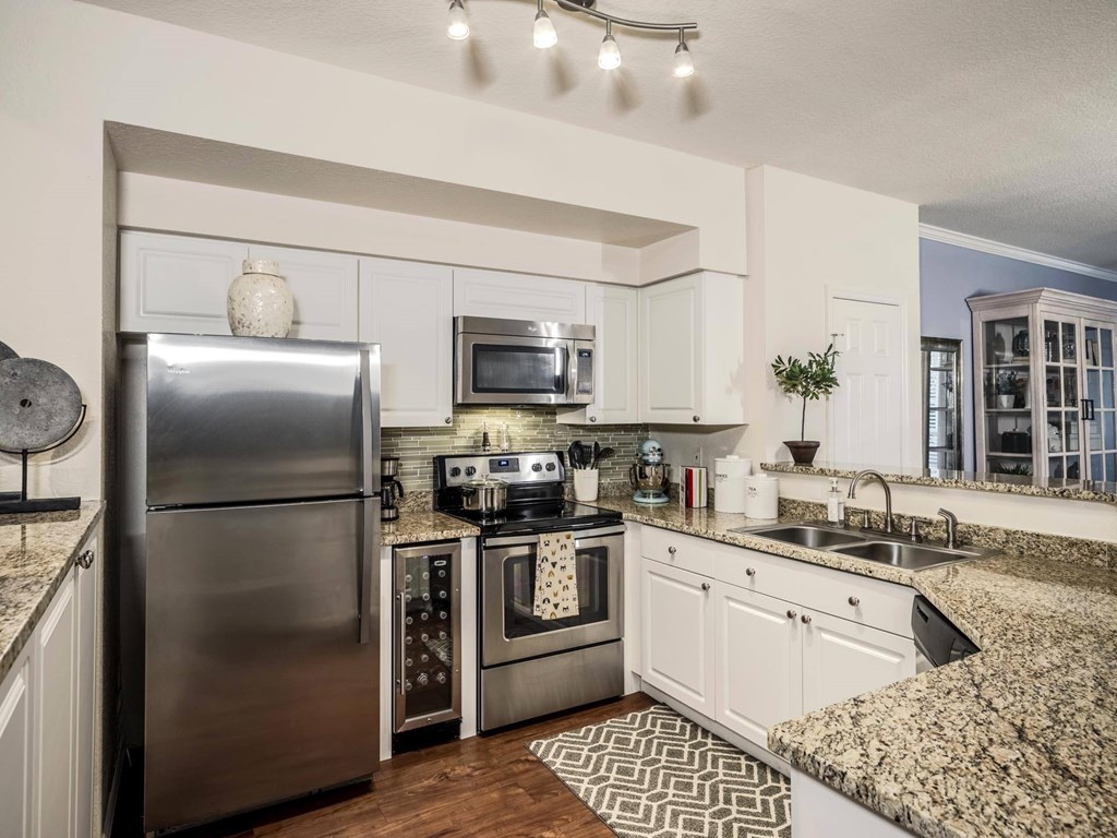 Apartment kitchen with stainless appliances and granite counters at Magnolia Carillon