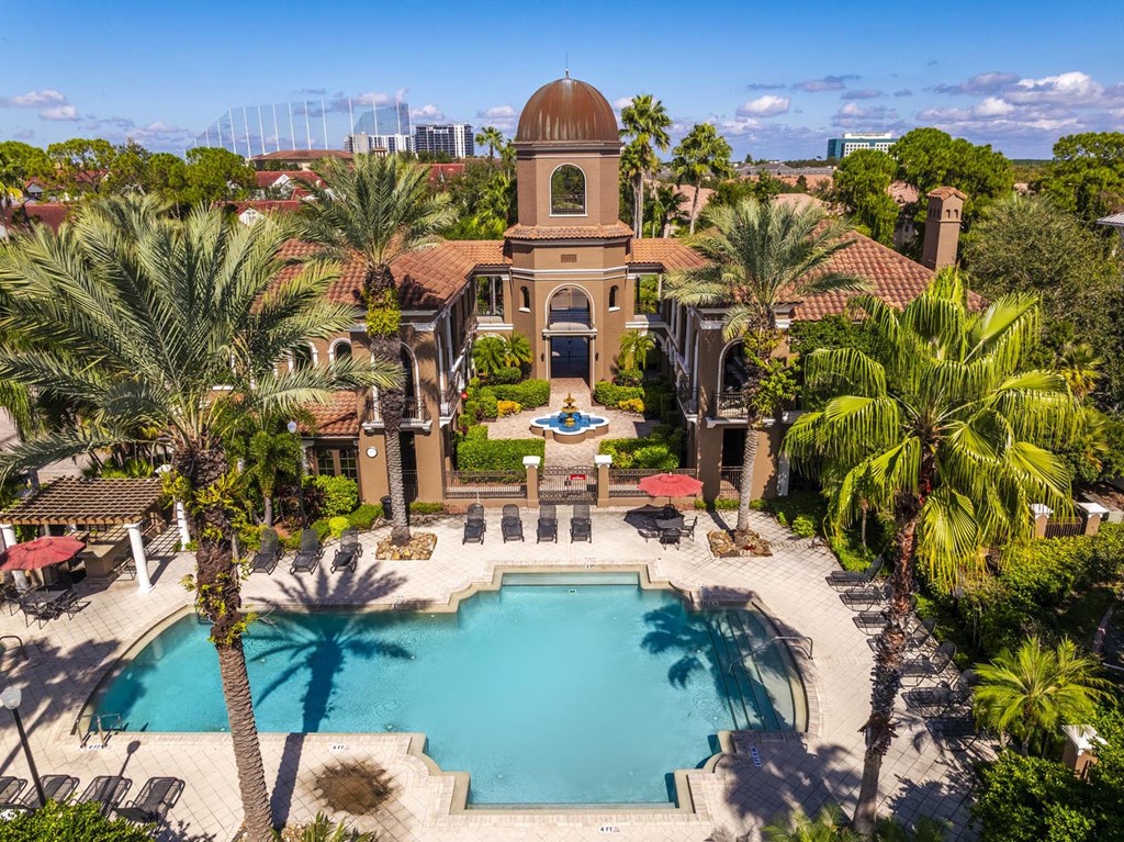 Aerial of courtyard and pool framed by palm trees and lounge seating