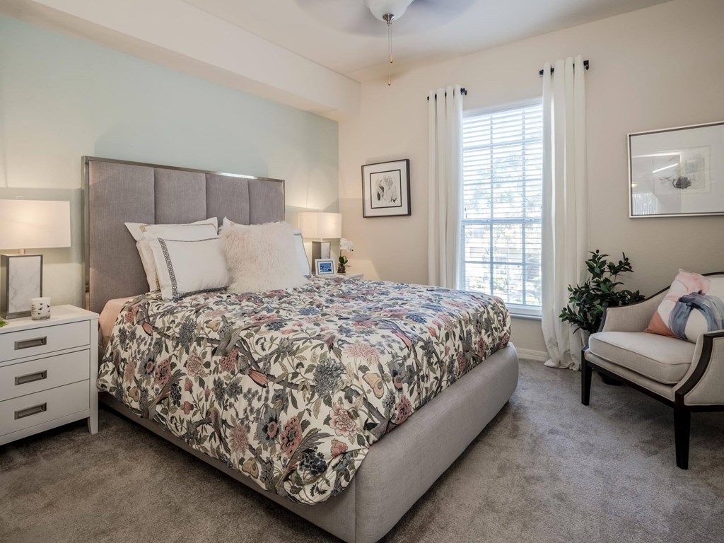 Bedroom with upholstered headboard, floral bedding and soft natural light