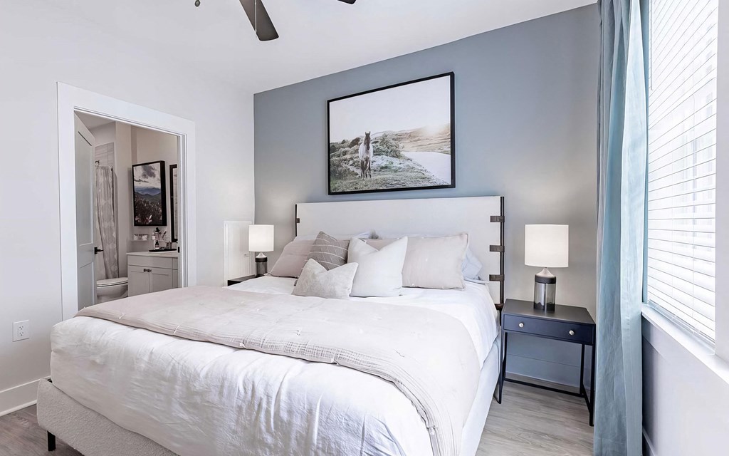 Modern bedroom with ceiling fan and en-suite bathroom at Novel Cary