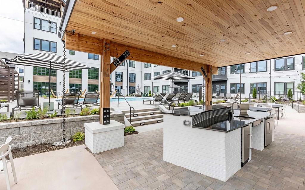 Full outdoor countertop with refrigerators under a modern pergola next to the pool at Novel Cary