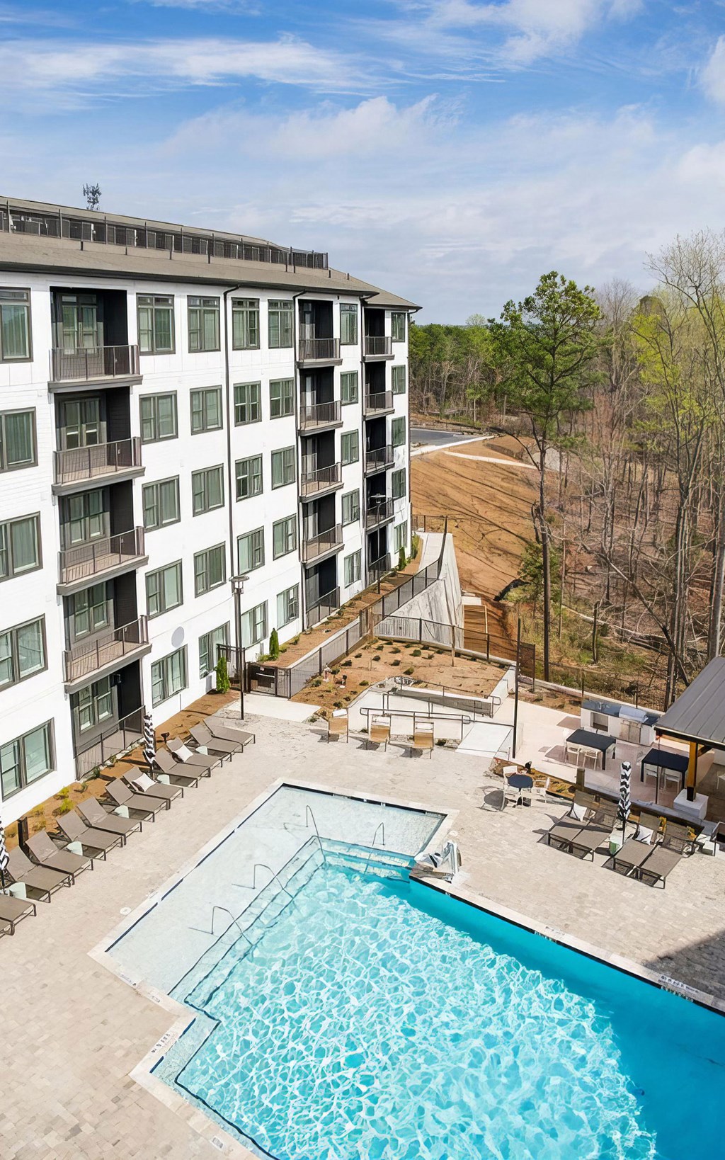 Large outdoor saltwater pool with deep and shallow areas and lounge seating at Novel Cary