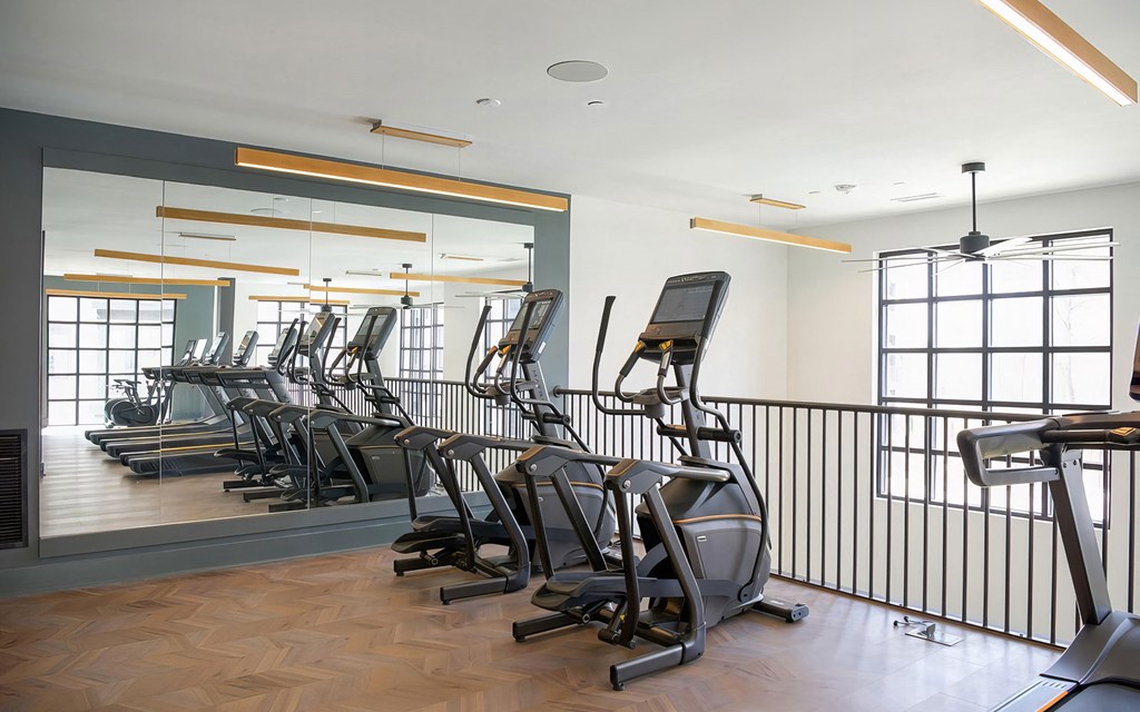 Second-story cardio area with modern elliptical machines at Novel Cary