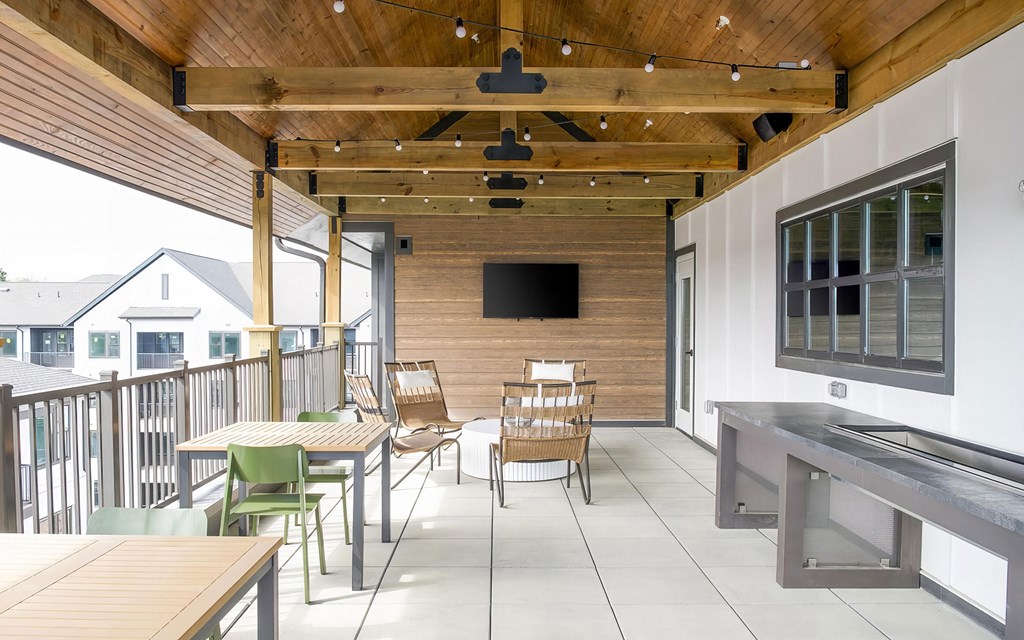 Social elevated outdoor space with seating and string lights at Novel Cary