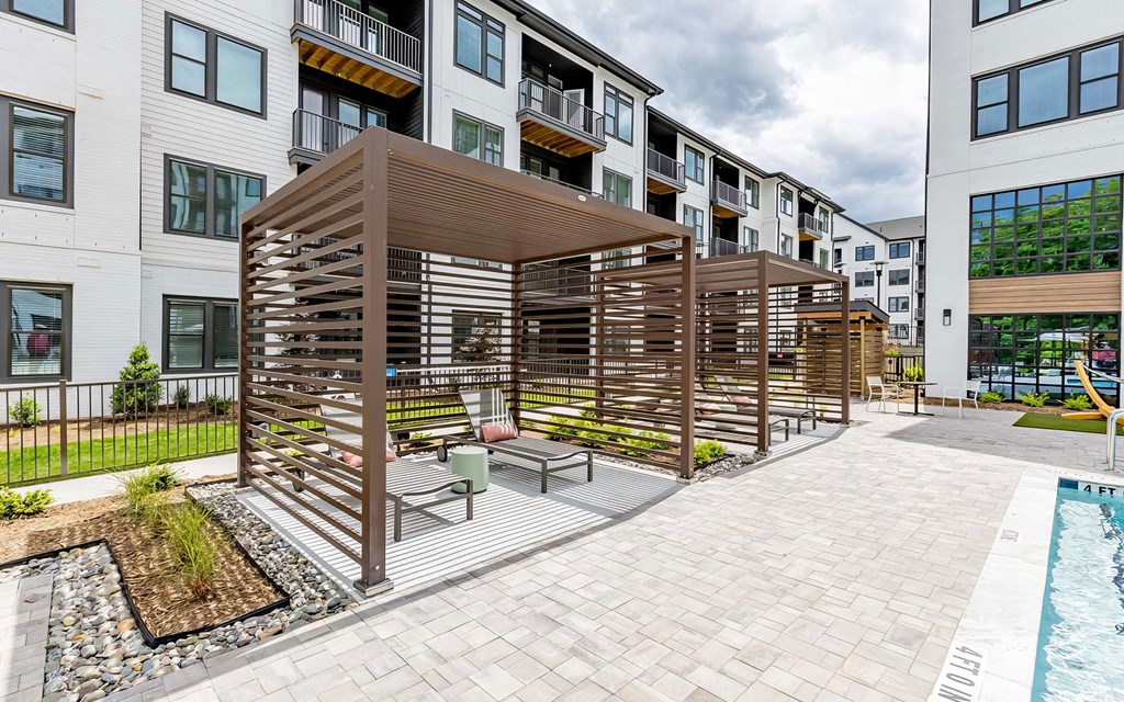 Sophisticated outdoor pool area with cabanas and lounge chairs at Novel Cary