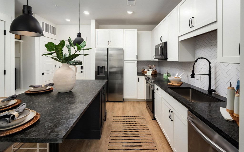 Contemporary Kitchen with Dark Countertops, White Cabinets & Undermount Sink