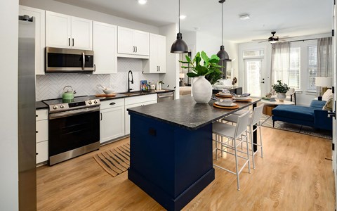 a large kitchen with a blue island and white cabinets