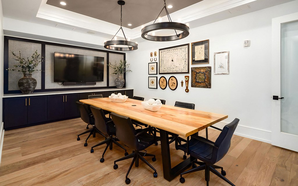 Conference Room with Wall-Mounted TV, Art Gallery, and Natural Wood Table