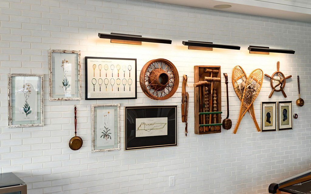 Eclectic Wall Display Featuring Framed Art, Snowshoes, and Vintage Sports Gear