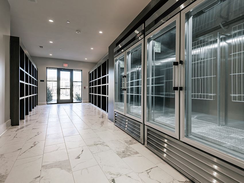 a hallway with glass doors and marble flooring