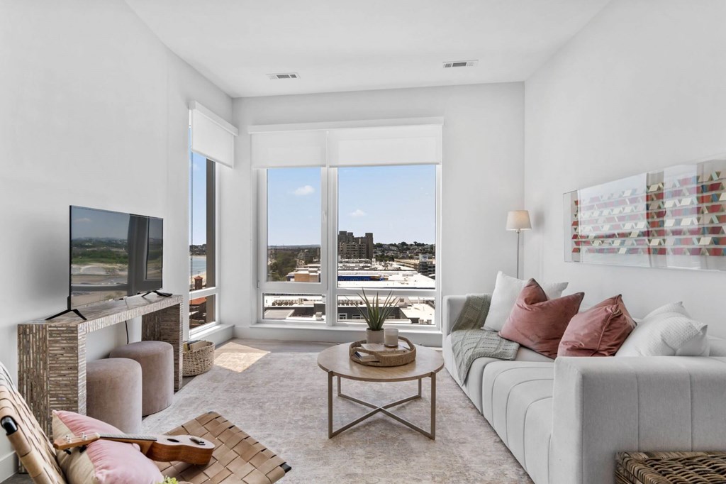 A living room with a flat screen TV and a view of the city.