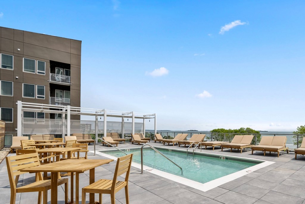 A poolside table and chairs are set up on a patio.