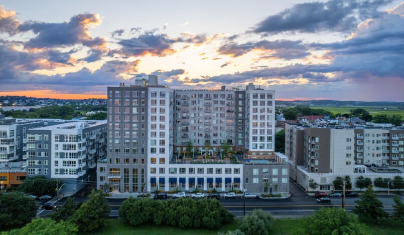 A large white building with a parking lot in front of it.