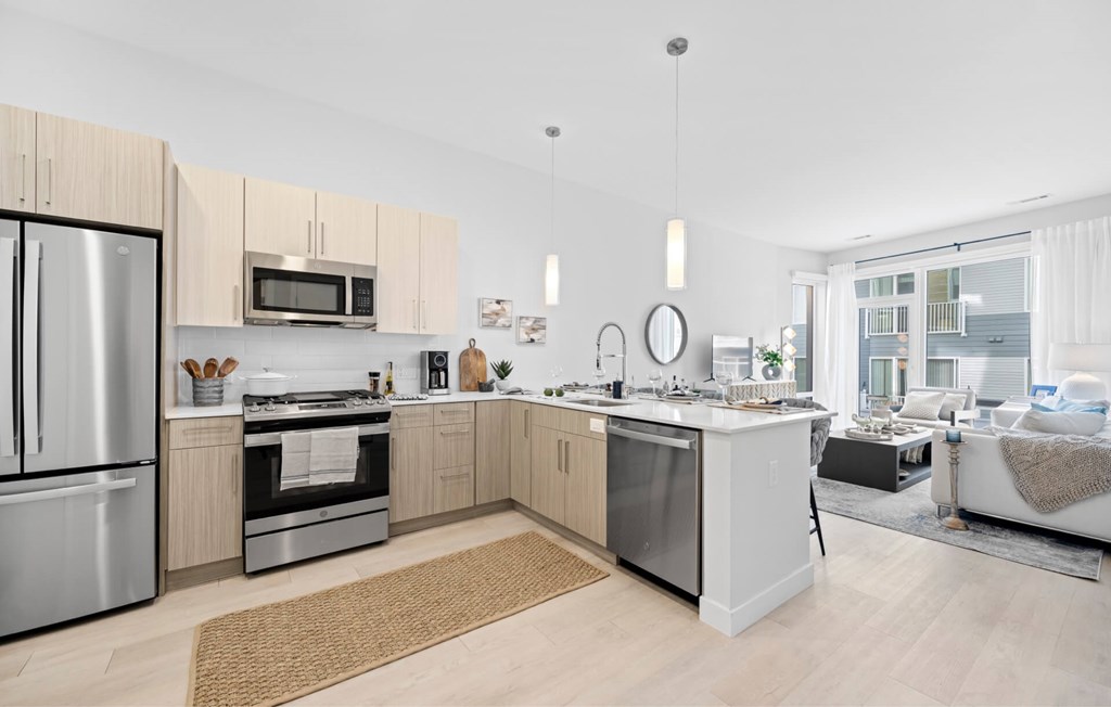 A modern kitchen with a refrigerator, oven, and microwave.