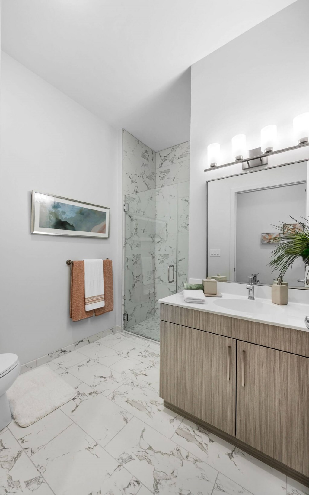 A bathroom with a toilet, sink, and a mirror.