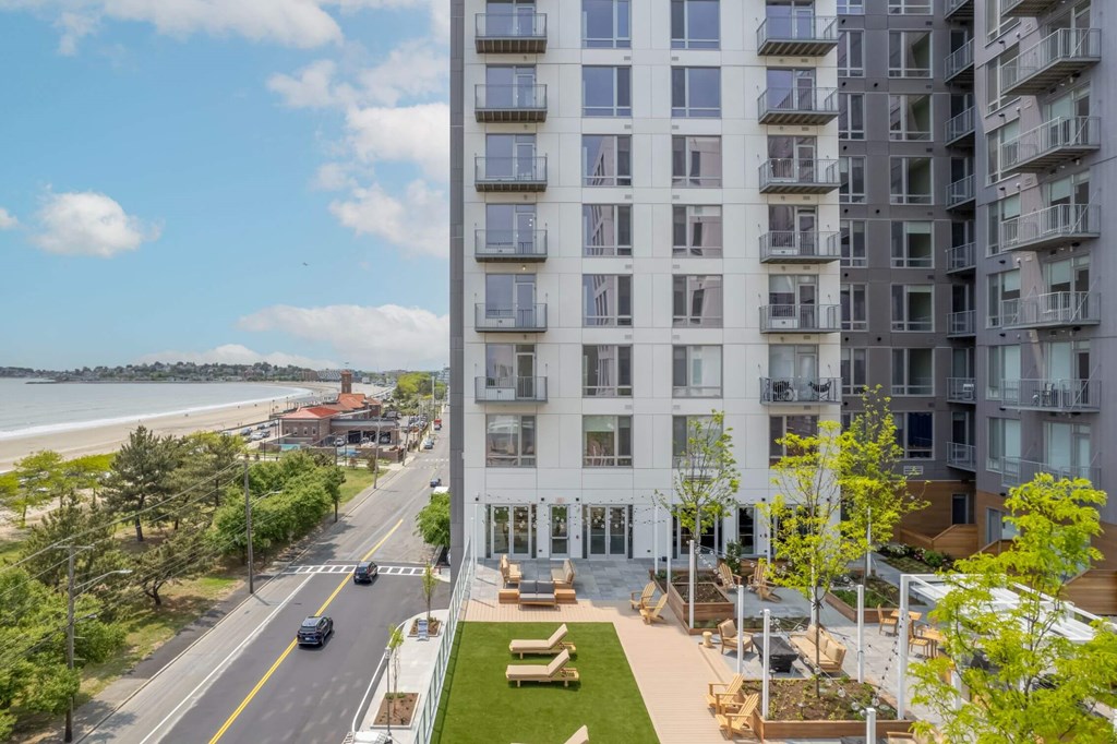 A view of a street with cars and apartment buildings.