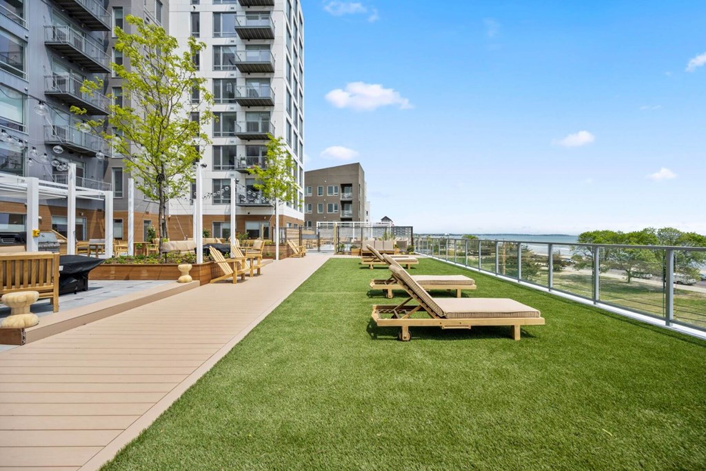 A grassy area with benches and a fence in front of a building.