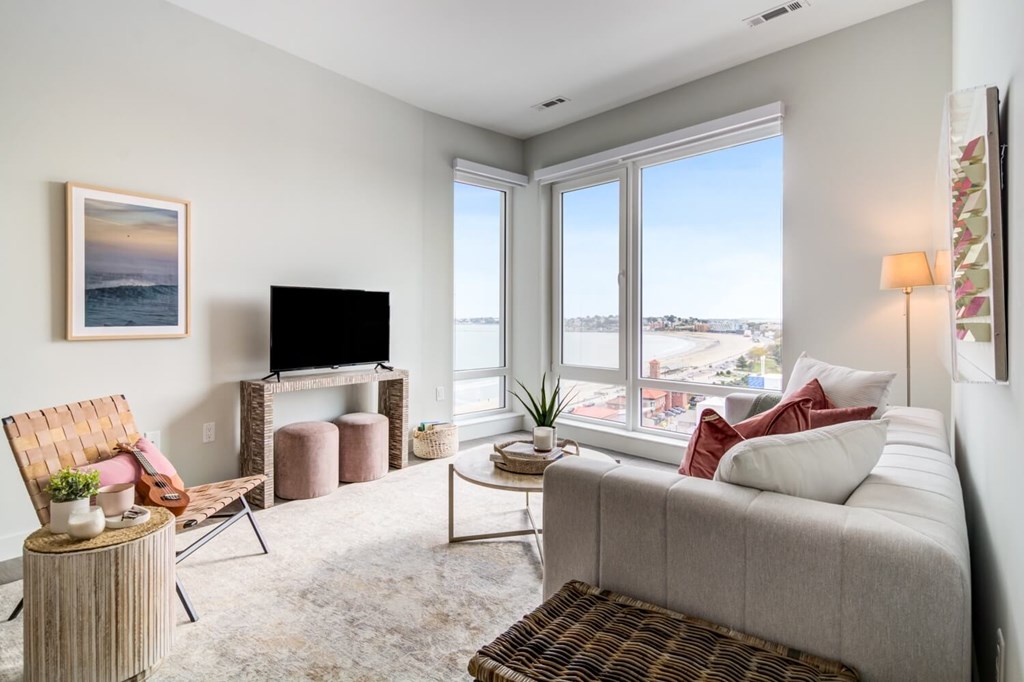 A living room with a couch, chair, and television.