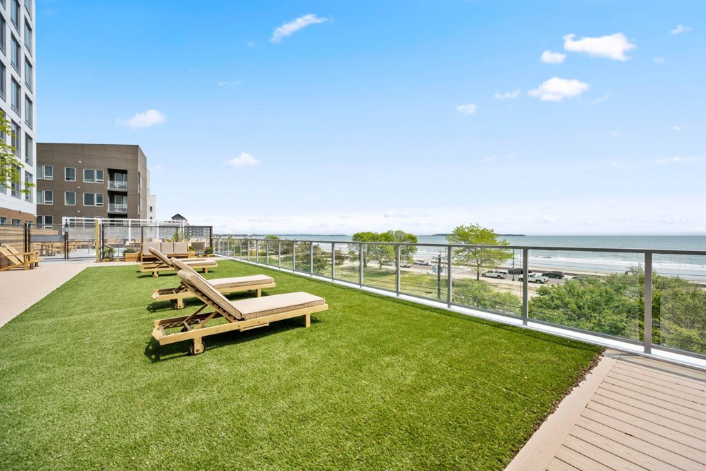 A patio with a table and chairs overlooking the ocean.