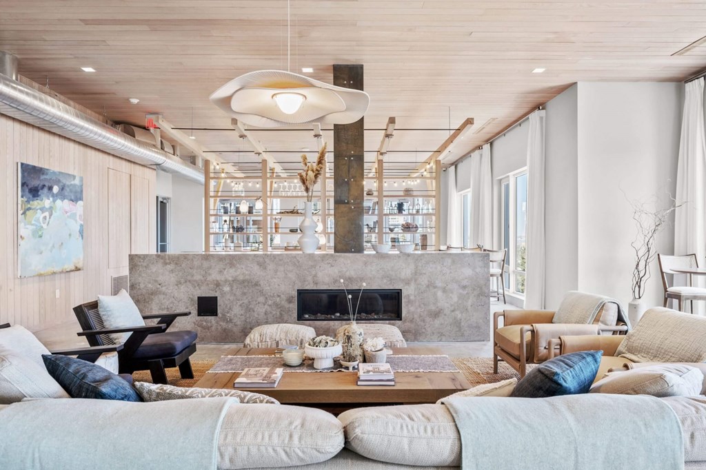 A modern living room with a fireplace and a large painting on the wall.