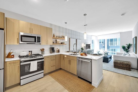 A modern kitchen with wooden cabinets and stainless steel appliances.