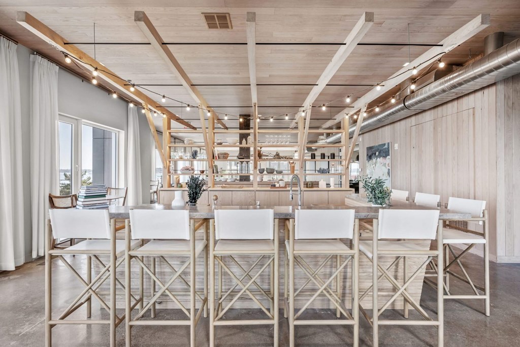 A long table with chairs is set up in a room with wooden beams on the ceiling.