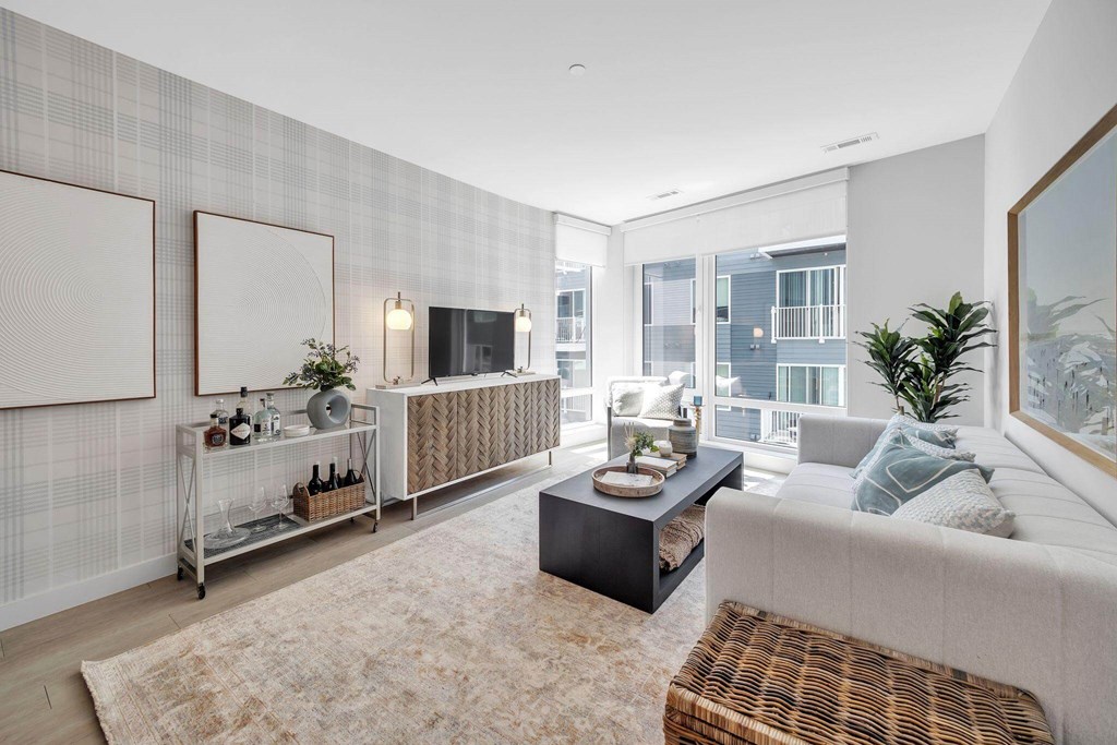 A modern living room with a large window and a balcony.