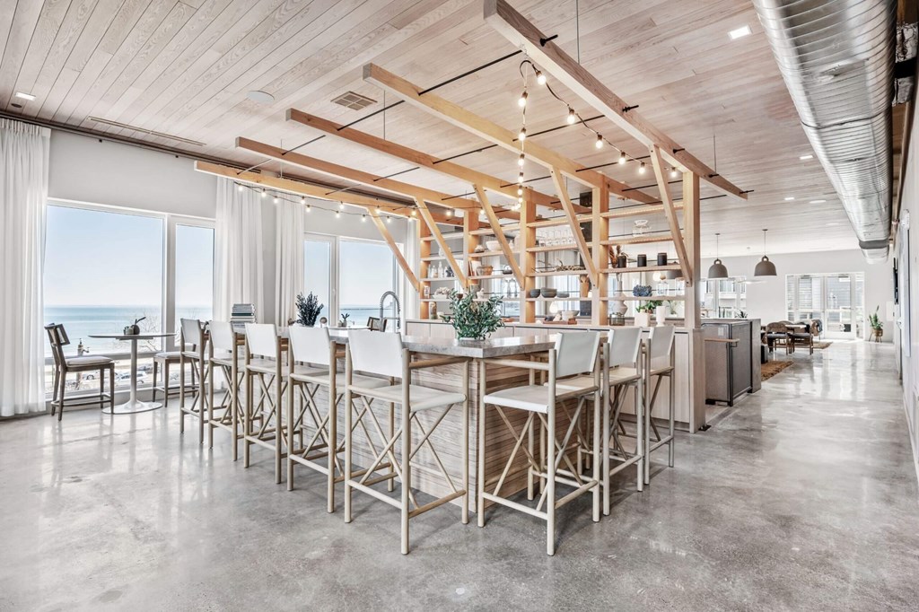A modern kitchen with a large island and wooden beams on the ceiling.